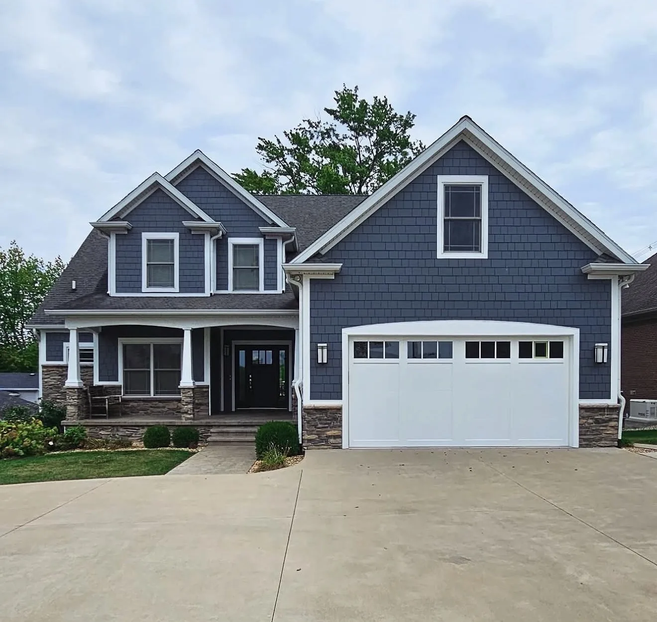 Jones & Sons exterior painting project: blue-gray home with white trim.